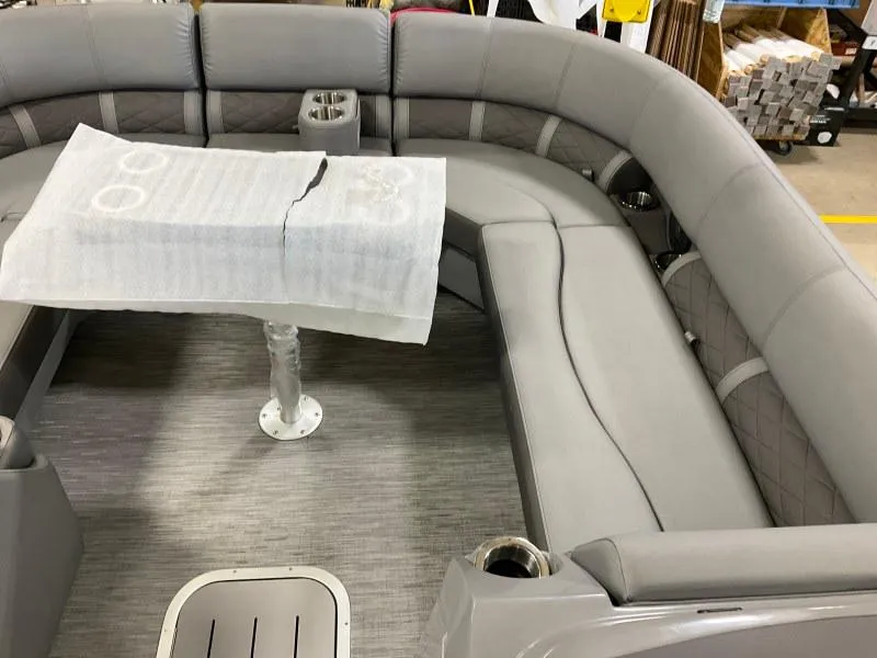 Slide: The Image of 2023 Bennington 21LSB pontoon boat interior with gray seating and table. - 12