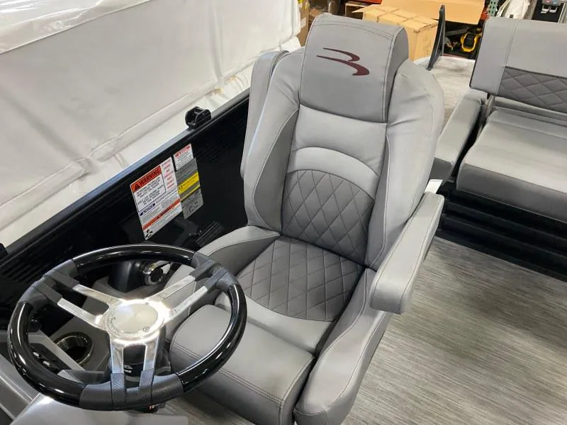 Slide: The Image of 2023 Bennington 21LSB boat interior with gray captain's chair and steering wheel. - 13