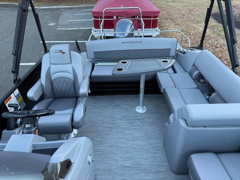 Slide: The Image of 2023 Bennington 21LSB pontoon boat interior with gray seating and table. - 19