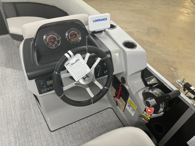 Slide: The Image of 2025 Harris Cruiser 190 boat dashboard with steering wheel and Lowrance navigation system. - 6