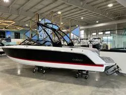 Slide: The Image of 2024 Cobalt CS23 boat in showroom, sleek black and white design. - 12