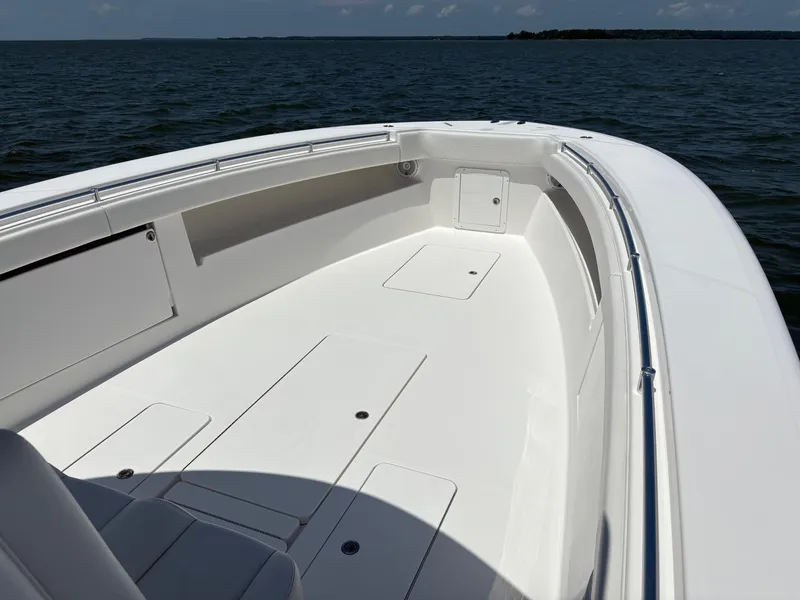 Slide: The Image of 2016 Invincible 42 Open Fisherman boat on calm waters, showcasing spacious deck. - 9