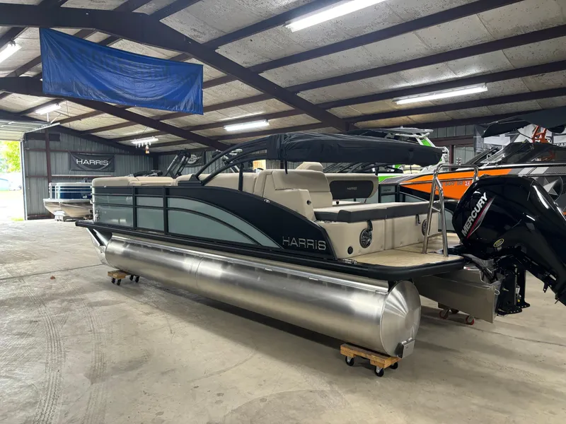Slide: The Image of 2025 Harris Cruiser 230 pontoon boat in a spacious indoor showroom. - 12