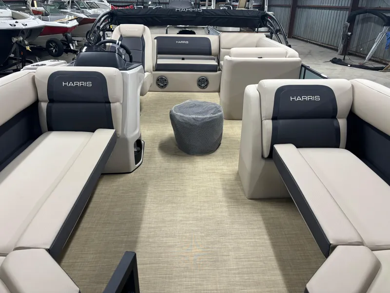 Slide: The Image of 2025 Harris Cruiser 230 pontoon boat interior with beige and black seating. - 2