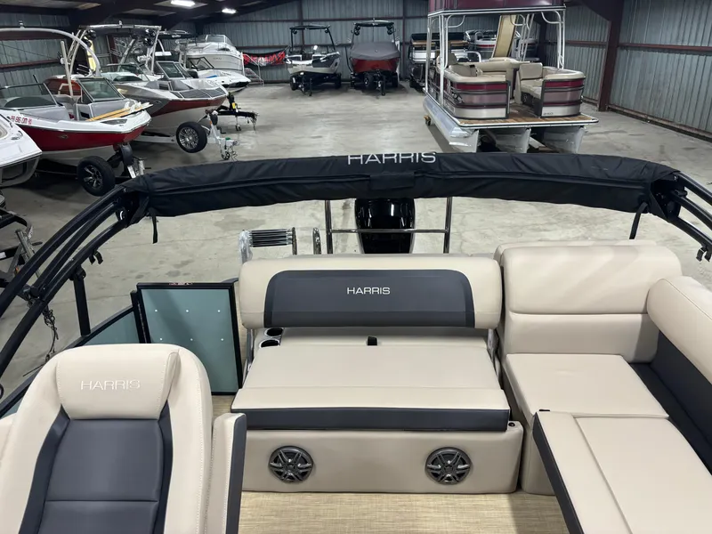 Slide: The Image of 2025 Harris Cruiser 230 pontoon boat interior in showroom with multiple boats. - 7