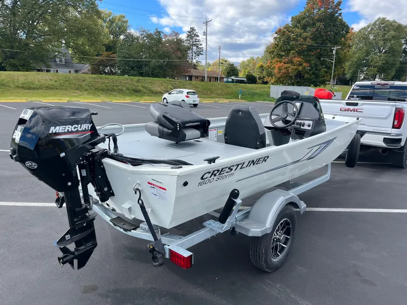 Slide: The Image of 2025 Crestliner 1600 Storm boat with Mercury engine on trailer in parking lot. - 2