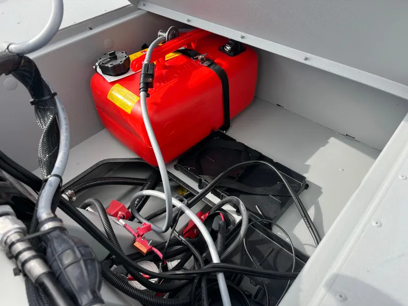 Slide: The Image of 2025 Crestliner 1600 Storm boat compartment with red fuel tank and wiring. - 3