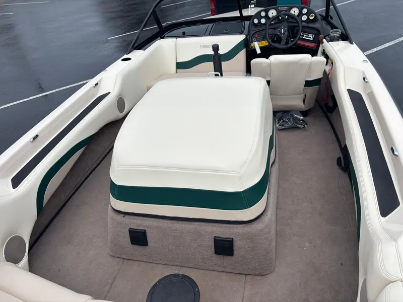 Slide: The Image of 1995 Correct Craft Ski Nautique interior with beige and green upholstery, steering wheel, and dashboard. - 1
