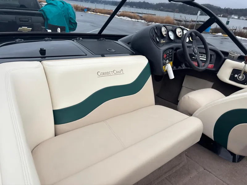 Slide: The Image of 1995 Correct Craft Ski Nautique interior with beige and green seating, dashboard, and steering wheel. - 10