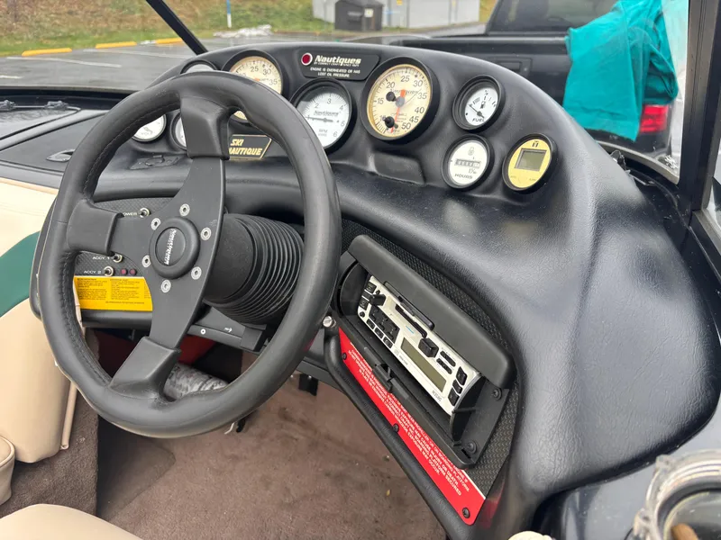 Slide: The Image of 1995 Correct Craft Ski Nautique dashboard with steering wheel and gauges. - 3