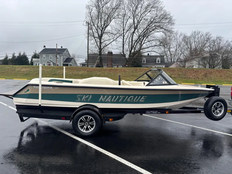 Slide: The Image of 1995 Correct Craft Ski Nautique boat on trailer in parking lot, overcast day. - 7