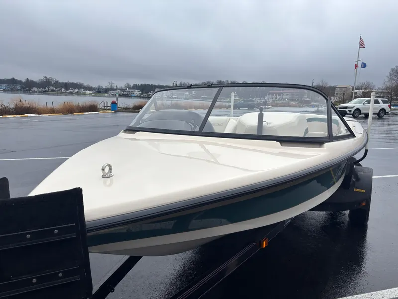 Slide: The Image of 1995 Correct Craft Ski Nautique boat on trailer, parked near a lake on a cloudy day. - 9