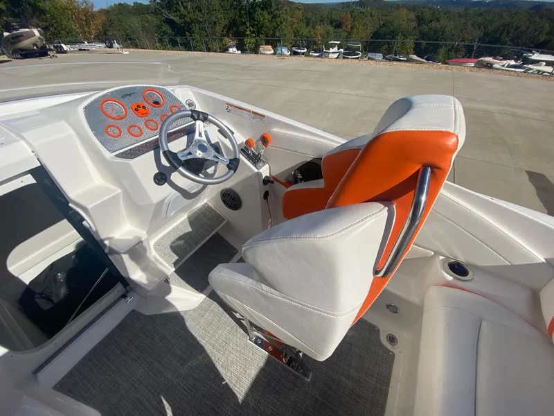 Slide: The Image of 2019 Baja 24 Outlaw boat interior with orange and white seating, modern dashboard. - 12