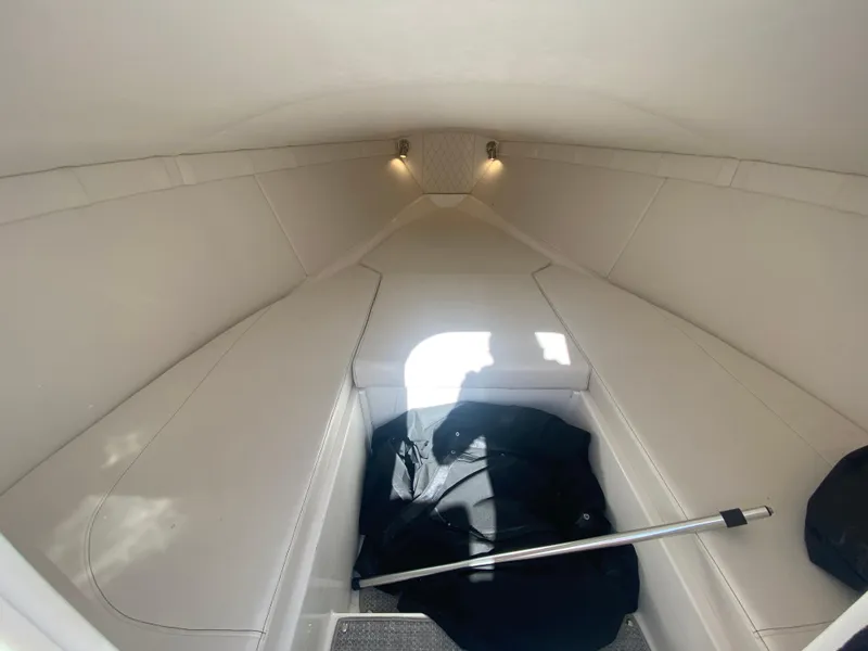 Slide: The Image of 2019 Baja 24 Outlaw cabin interior with white upholstery and overhead lighting. - 21