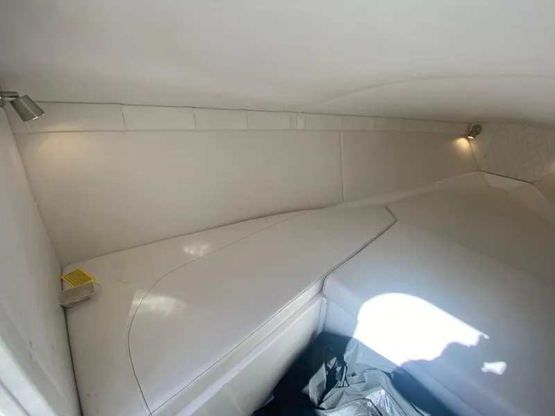 Slide: The Image of 2019 Baja 24 Outlaw cabin interior with white upholstery and ambient lighting. - 22