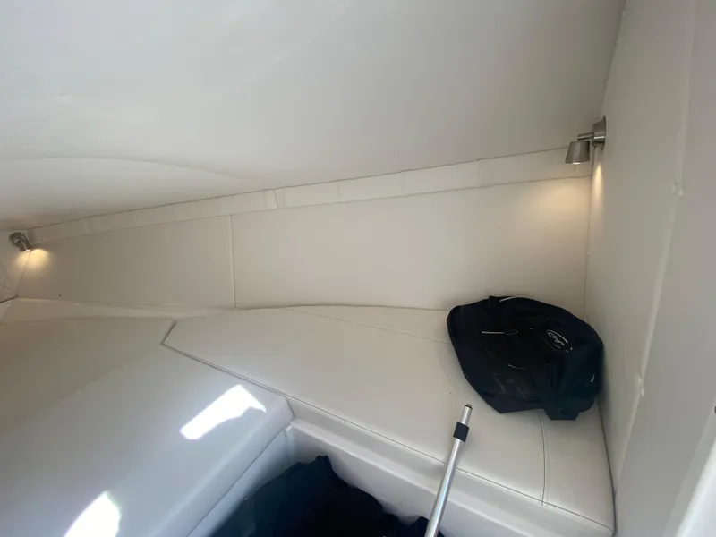 Slide: The Image of Interior cabin of 2019 Baja 24 Outlaw boat with white seating and lighting. - 23