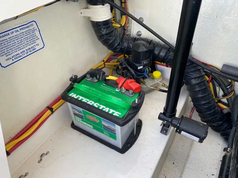 Slide: The Image of 2019 Baja 24 Outlaw boat battery compartment with Interstate battery and wiring. - 27