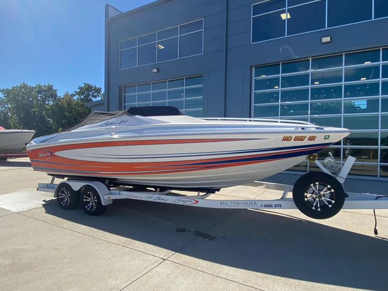 Slide: The Image of 2019 Baja 24 Outlaw speedboat on trailer, parked outside modern building. - 33
