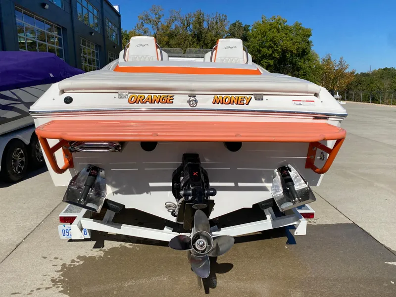 Slide: The Image of 2019 Baja 24 Outlaw boat, rear view, labeled "Orange Money," parked outdoors. - 4