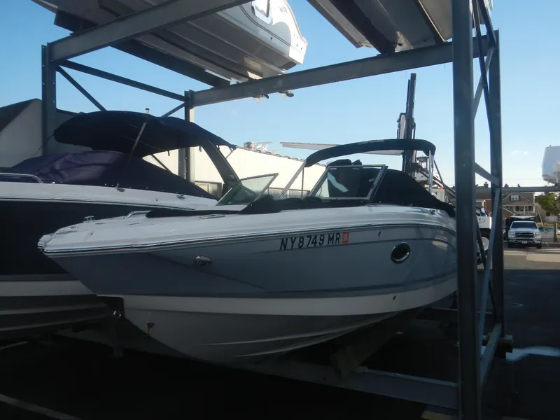 Slide: The Image of 2020 Chaparral 24 SSI boat in storage, side view, with registration number visible. - 1