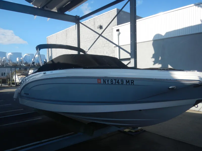 Slide: The Image of 2020 Chaparral 24 SSI boat in storage, side view under metal canopy. - 3