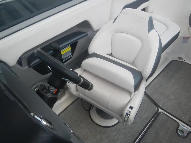 Slide: The Image of 2020 Chaparral 24 SSI boat interior with white captain's seat and steering wheel. - 6