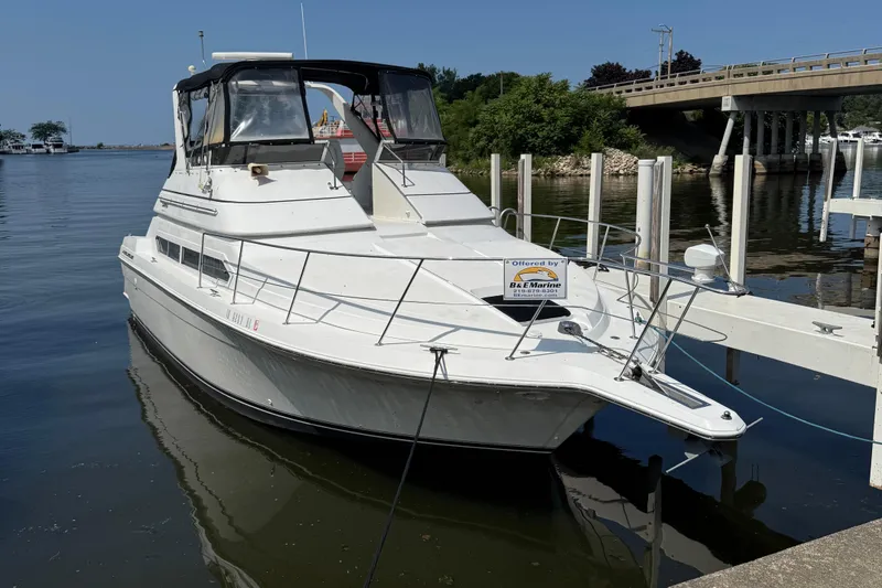 The Image of 1997 Carver 380 Santego SE yacht docked by a bridge on a sunny day. - 0