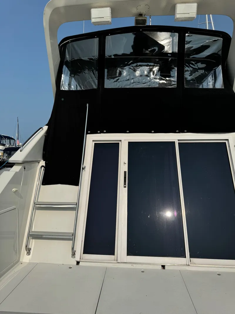 Slide: The Image of 1997 Carver 380 Santego SE yacht with black cabin enclosure and sliding doors. - 11