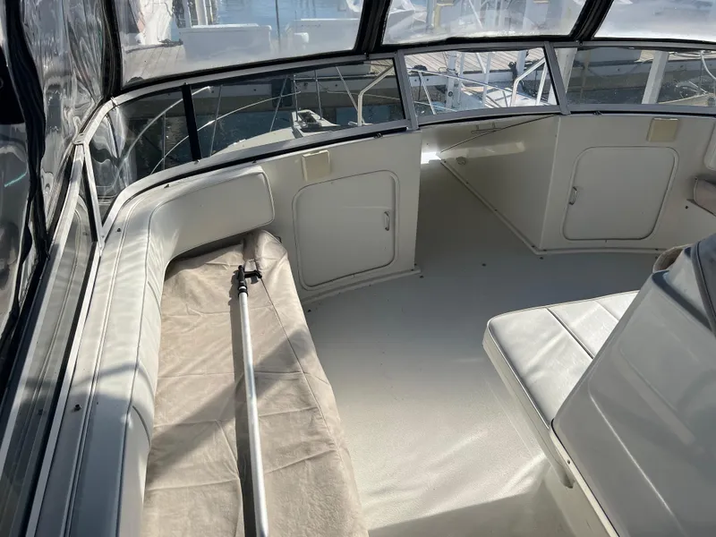 Slide: The Image of 1997 Carver 380 Santego SE boat interior with white seating and windows. - 13