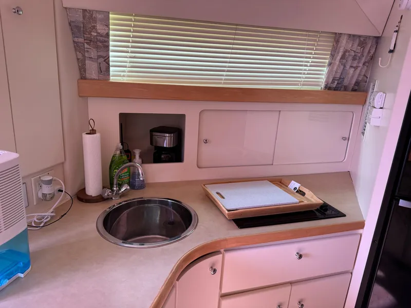 Slide: The Image of 1997 Carver 380 Santego SE yacht kitchen with sink, cutting board, and blinds. - 33