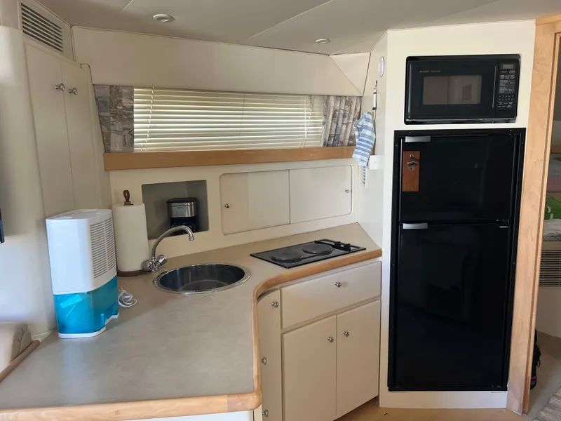 Slide: The Image of 1997 Carver 380 Santego SE yacht kitchen with sink, stove, and microwave. - 16