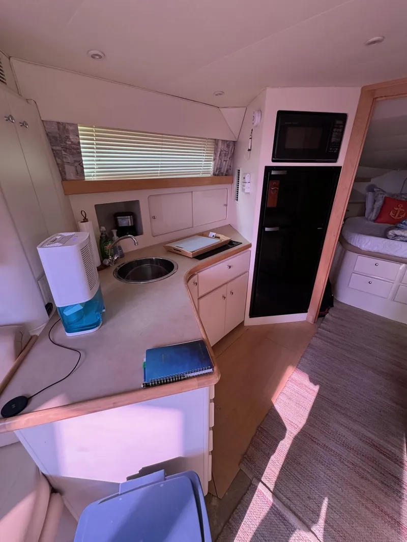 Slide: The Image of 1997 Carver 380 Santego SE yacht interior with kitchenette and cozy cabin space. - 36