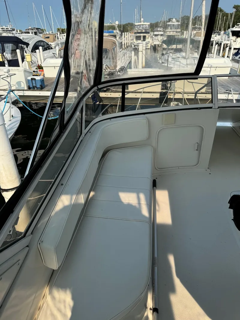 Slide: The Image of 1997 Carver 380 Santego SE yacht interior with white seating and marina view. - 9