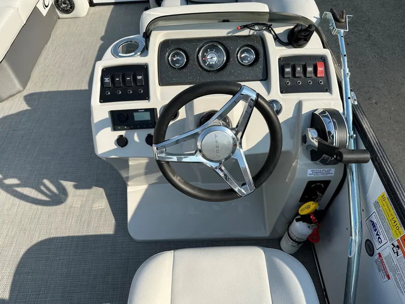 Slide: The Image of 2022 Crest Classic DLX 220 boat dashboard with steering wheel and controls. - 10