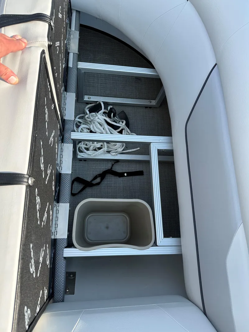 Slide: The Image of Storage compartment in 2022 Crest Classic DLX 220 boat with ropes and container. - 11
