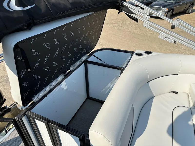 Slide: The Image of 2022 Crest Classic DLX 220 boat interior with white seating and storage compartment. - 13