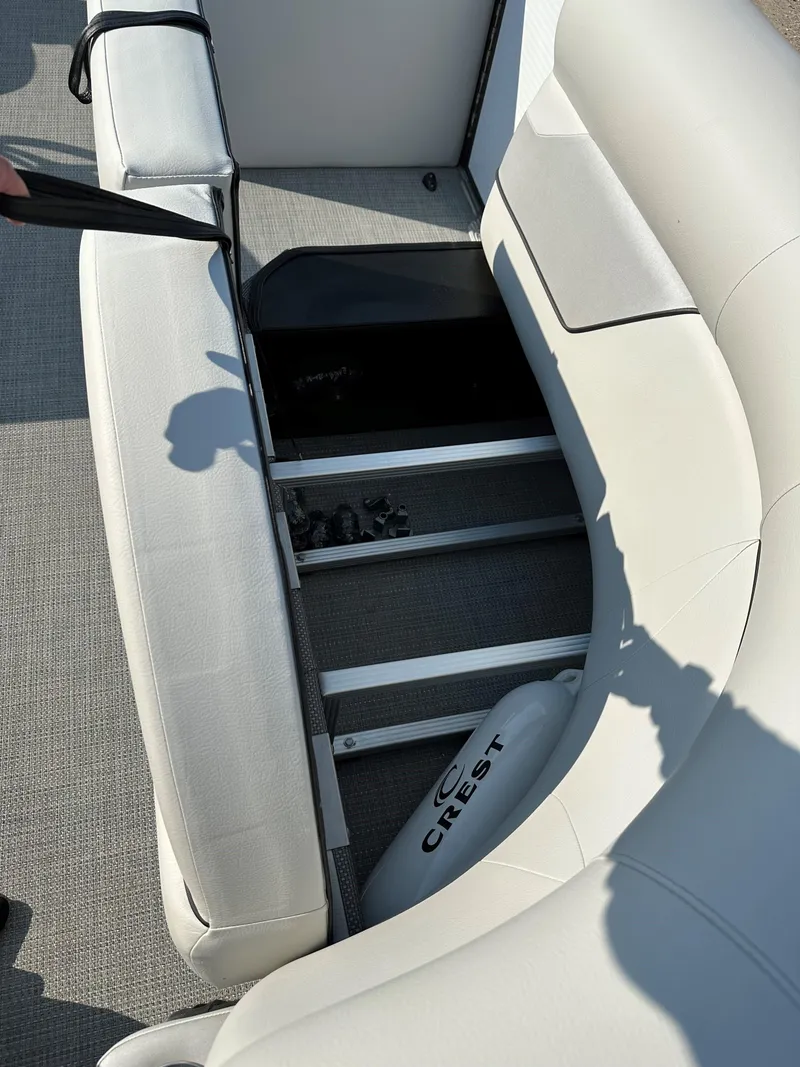 Slide: The Image of 2022 Crest Classic DLX 220 boat interior with storage compartment and seating. - 16