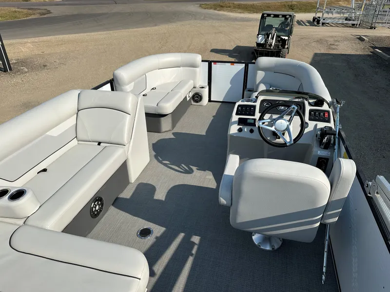 Slide: The Image of 2022 Crest Classic DLX 220 pontoon boat interior with plush seating and modern helm. - 18