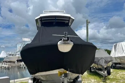 Slide: The Image of 2022 Wellcraft 222 Fisherman boat covered, docked under cloudy sky. - 4
