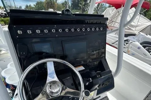 Slide: The Image of 2022 Wellcraft 222 Fisherman boat dashboard with steering wheel and control panel. - 5