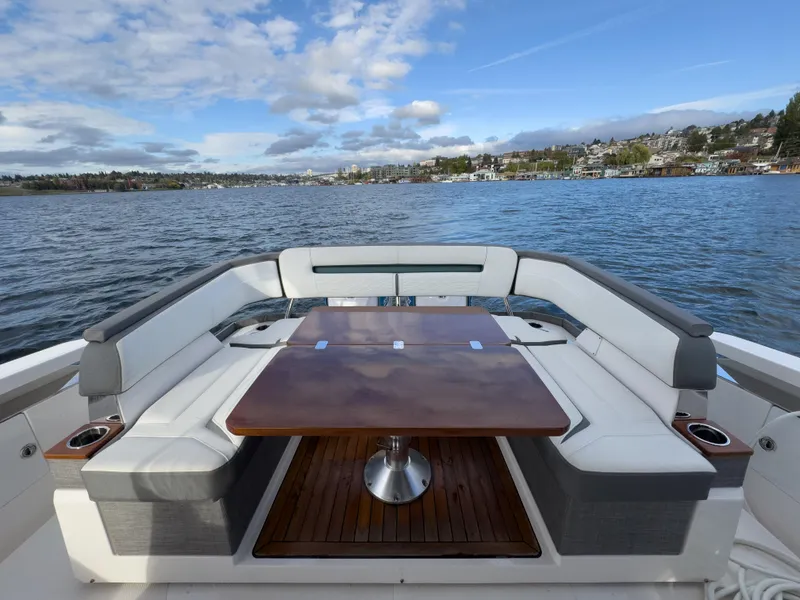 Slide: The Image of 2020 Tiara Sport 38 LS boat with elegant seating and table on a scenic lake. - 19
