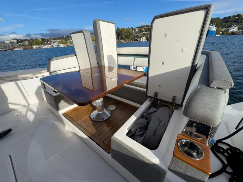 Slide: The Image of 2020 Tiara Sport 38 LS boat interior with seating and table on a sunny day. - 21