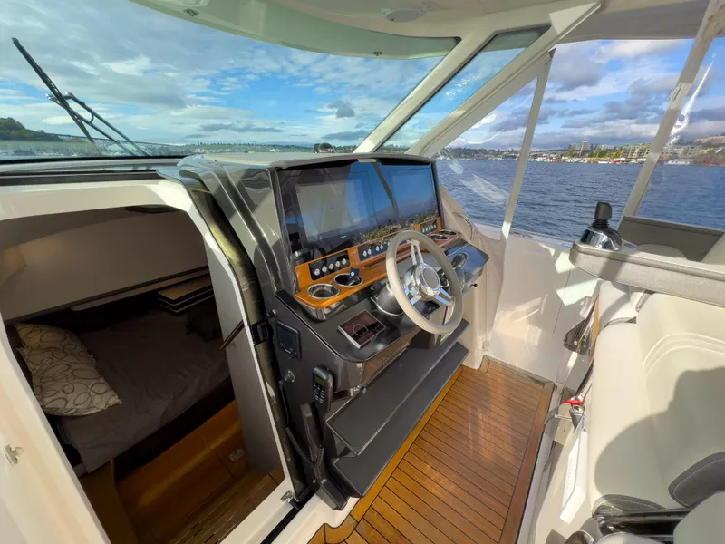 Slide: The Image of 2020 Tiara Sport 38 LS boat interior with helm, steering wheel, and cabin view. - 27