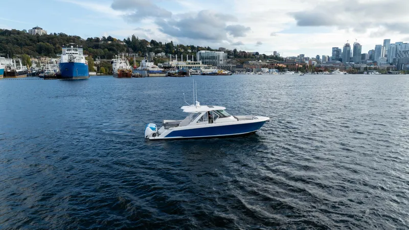 Slide: The Image of 2020 Tiara Sport 38 LS boat on a scenic waterfront with city skyline. - 3