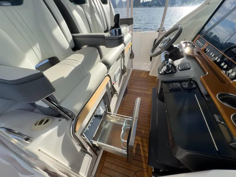 Slide: The Image of 2020 Tiara Sport 38 LS boat interior with helm, seating, and storage drawer. - 30