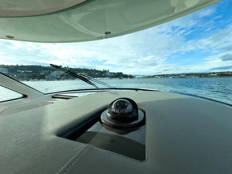 Slide: The Image of 2020 Tiara Sport 38 LS boat dashboard with compass, scenic water view. - 32