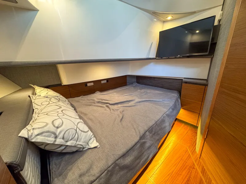 Slide: The Image of 2020 Tiara Sport 38 LS cabin with bed, TV, and wooden flooring. - 35