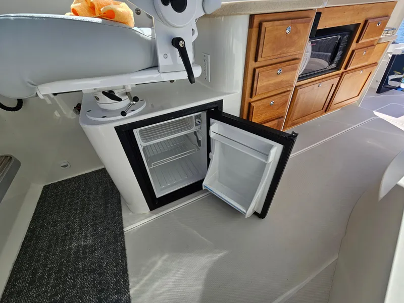 Slide: The Image of 2008 Back Cove 33 interior with open mini fridge and wooden cabinetry. - 25