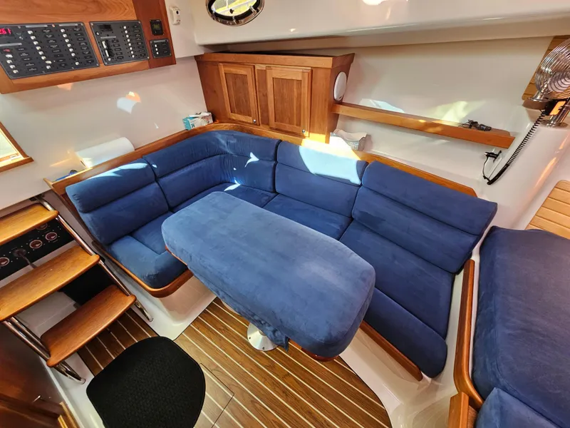 Slide: The Image of Interior of 2008 Back Cove 33 yacht with blue cushioned seating and wooden accents. - 26