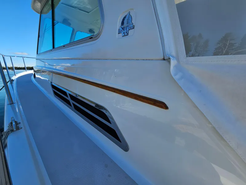 Slide: The Image of 2008 Back Cove 33 boat exterior with sleek design and logo detail. - 36